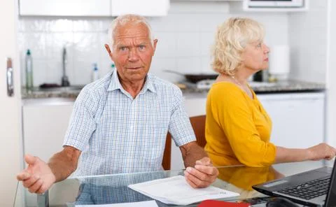 Unhappy mature couple with documents having conflict in home Stock Photos