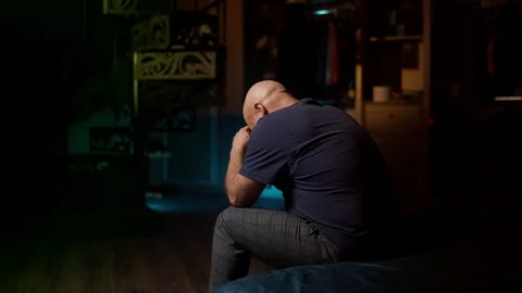 Unhappy middle-aged man cries after unpaid bills lead to electricity shutoff Stock Footage 342520676