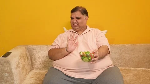 Unhappy overweight indian man avoid healthy salad food. Plus size guy refus.. Stock Footage 312908532