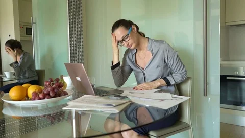 Unhappy, sad businesswoman working with laptop and documents by table in office Stock Footage