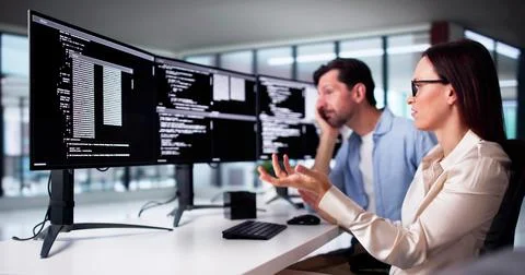 Unhappy Sad Developer Programmers In Stress Coding Software On Computer 写真素材