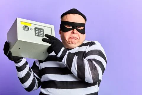 Unhappy sad thief cannot open the safe Foto stock