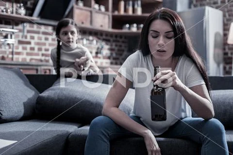 Unhappy sad woman looking at her bottle Stock Photos