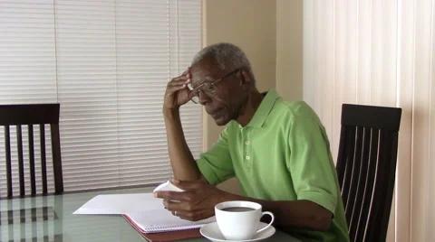 An unhappy senior citizen  using a calculator to figure out his finances Stock Footage