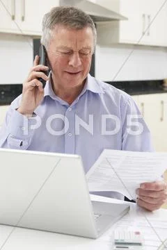 Unhappy Senior Man On Phone Querying Bill Stock Photos