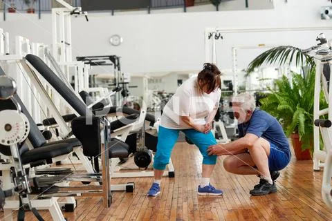 Unhappy senior woman with pain in knee. Stock Photos