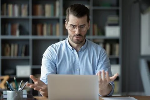 Unhappy shocked man having problem with laptop, looking at screen Stock Photos