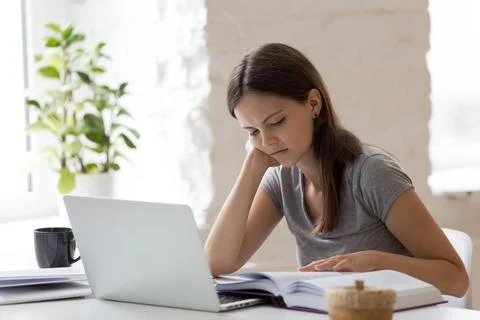 Unhappy teenager bored with studying at home Stock Photos