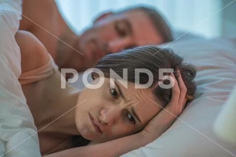 The unhappy woman lay near the man Stock Photos