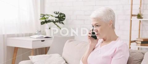 Unhappy worried senior woman talking on phone Stock Photos