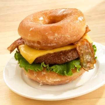 Unhealty Food Bacon Cheeseburger Served on Two Krispie Kreme Donuts Stock Photos