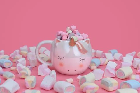 Unicorn mug with multi-colored marshmallows scattered around. Foto stock