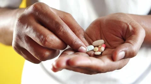 Unidentifiable person holding different types of medicine pills in hand wit.. Stock Footage 332777247