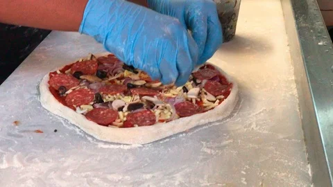 Unidentified chef sprinkle diced olive on pizza Видео 105588516
