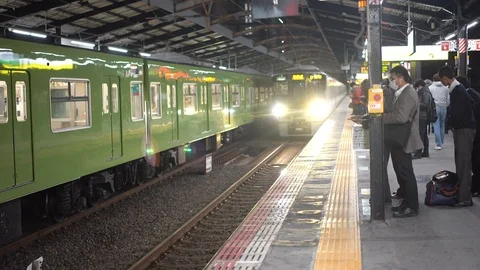 Unidentified commuters are seen waitng for train arrival at Osaka Station Stock Footage 98991359