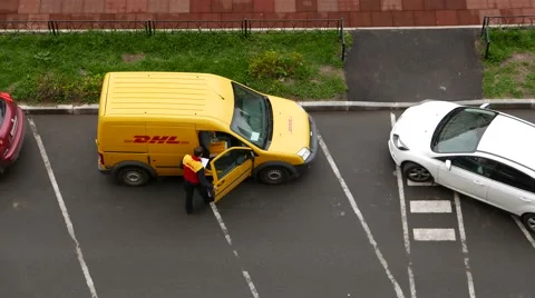 Unidentified courier stand inside open compartment door of yellow panel van Video stock 60498169
