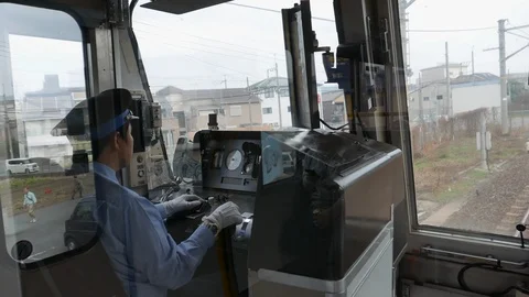 Unidentified Japanese train driver points and read station names Stock Footage 99586247
