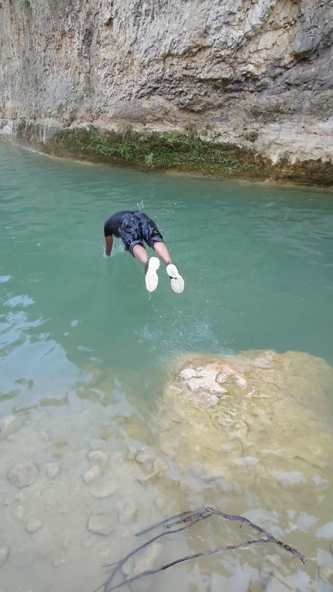 Unidentified Man Diving Into Clear Water From Rock Cliff - 4k Vertical Footage Video stock 337936706