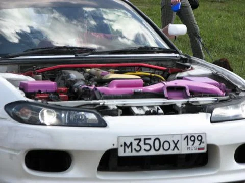 Unidentified mechanic is checking the engine oil of a car in a car show Stock Photos