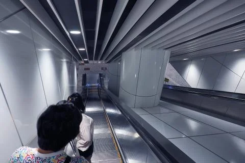 Unidentified people using automatic ladder escalator going dowstair at underg Foto stock