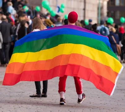Unidentified protester march with a large gay / LGBT rights rainbow flag Stock Photos