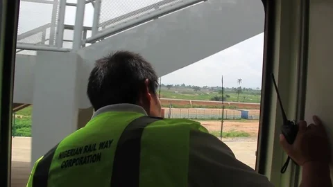 An unidentified train worker looks out as train comes to a halt Stock Footage 75893625