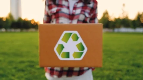 Unidentified woman pulls a cardboard box marked recycled raw material Stock Footage 116385341
