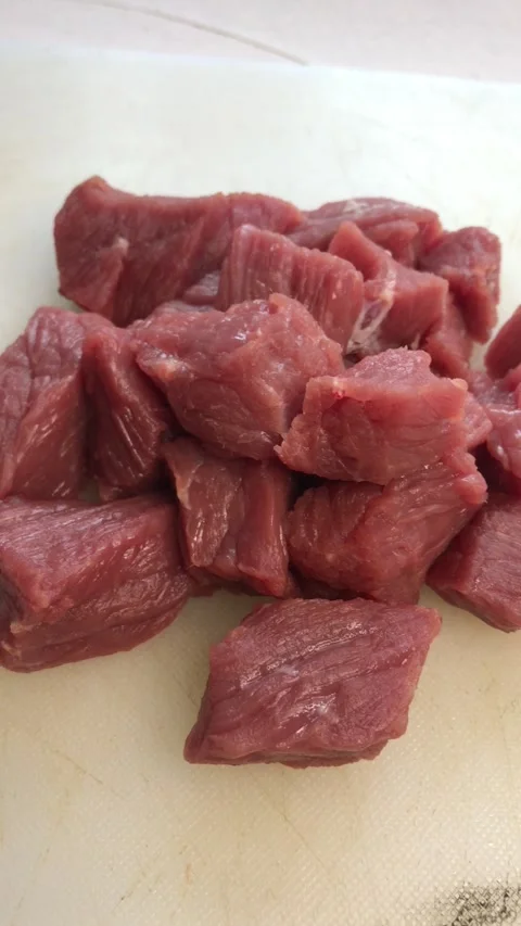 Uniform raw beef chunks in a compact pile, white background Stock Footage 310866293