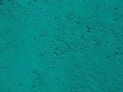 A uniform, textured wall surface coated in bright teal stucco paint showing.. Stock Photos