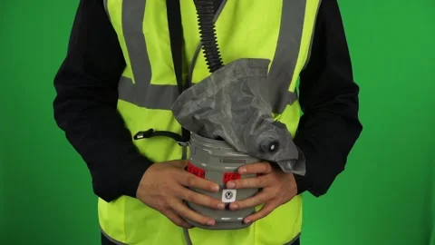 A uniformed employee shows the work of a self-rescuer on a green background Stock Footage 162035577