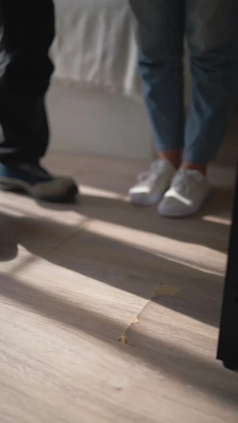 Uniformed handyman holding clipboard while discussing damaged laminate floo.. Stock Footage 344807734