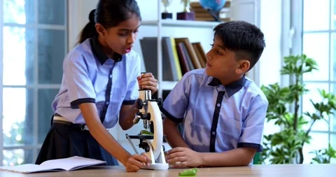 Uniformed Indian students in class room, studying science using microscope Stock Footage 342848703