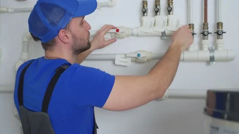 Uniformed plumber is at work - closing and opening the taps 스톡 동영상 151141499