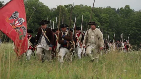 Uniformed Rev War Re-enactor Soldiers Marching with flags &amp; flintlocks Stock Footage 170500352