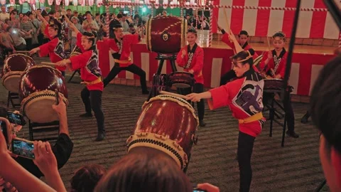 Uniformed Taiko Drum Team Performing Before a Striped Curtain Backdrop Stock Footage 345841400