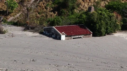 Uninhabitable house filled in by volcanic ashes and mud on Montserrat Stock Footage 89788257