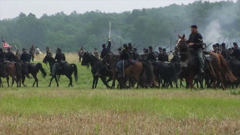 Union Cavalry Re-enactor troopers gallop across open battlefield Stock Footage 100823460