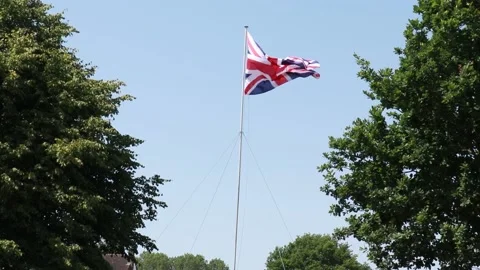 Union flag blowing in the wind in a field Stock Footage 226566218