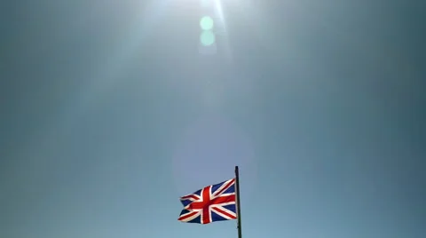 Union Jack flag blowing in wind against blue sky. Stock Footage 54662180