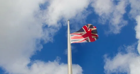 Union Jack Flag Flying At Half Mast Against The Sky In Cornwall, Following Stock Footage 209449280