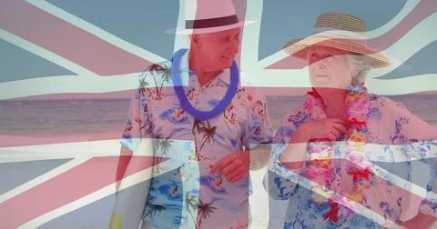 Union Jack flag image over elderly couple in tropical attire on beach Ilustração Stock