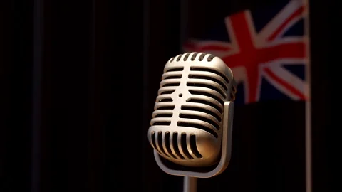Union Jack flag UK waving behind steady vintage style microphone Vídeo Stock 240136342