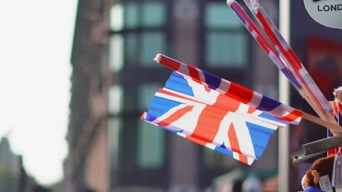 Union Jack flag waves in the breeze with city buildings in the background Stockbeeldmateriaal 331589631