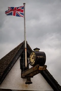 Union Jack flagging by a clock in a rooftop Stock Photos