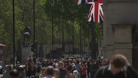 Union Jack flags, traffic, tourists and Big Ben, Whitehall, London, England Stock Footage 243077638