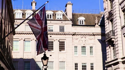 Union Jack fluttering in the wind on a sunny London street Video stock 142739509