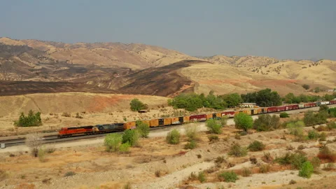 The Union Pacific train passes by landscape scorched by wildfires near Stock Footage 141568994