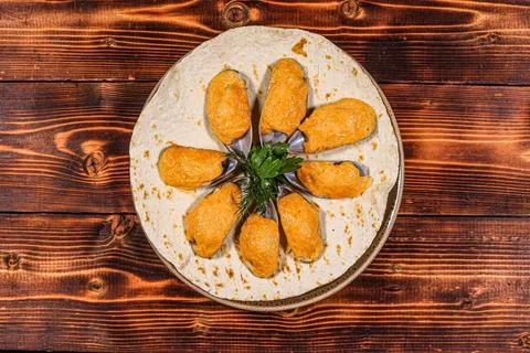 A unique and visually appealing presentation of baked mussels covered in a sa Stock Photos