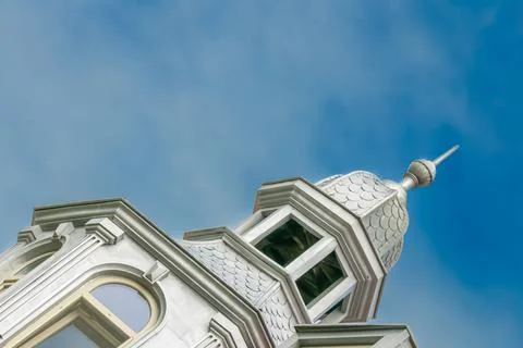 Unique architectural design highlighted by a tower reaching toward the blue.. Stock Photos