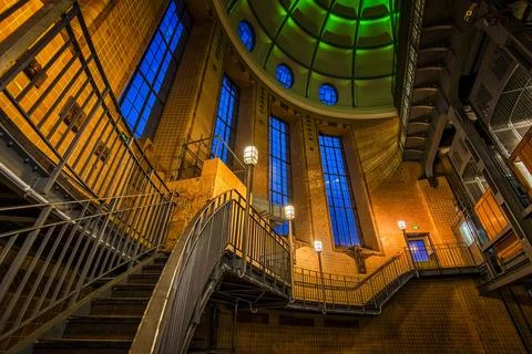 Unique architectural interior showcasing a spiral staircase and stained glass Foto stock